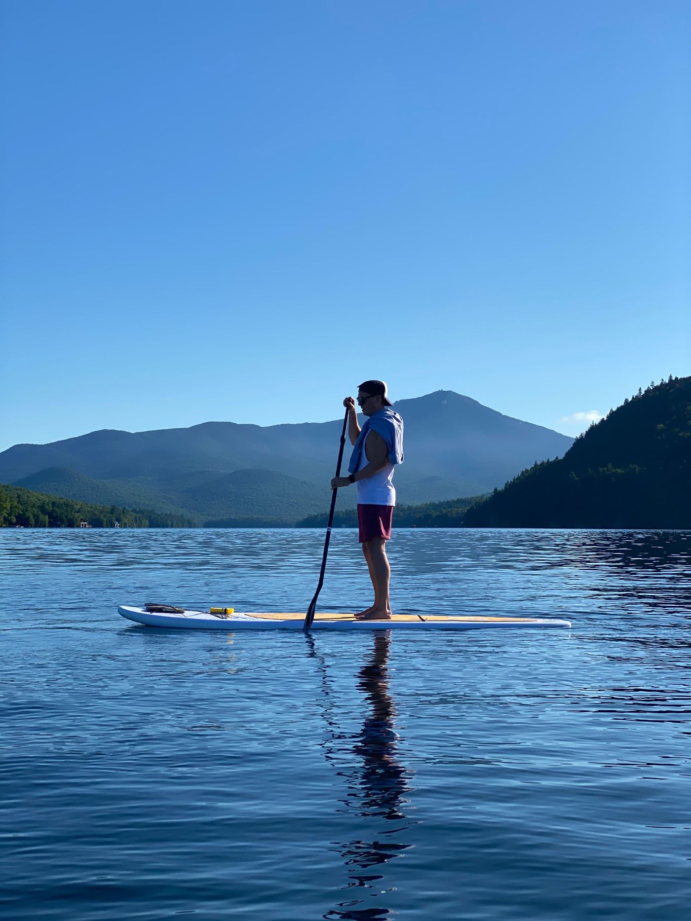 Paddleboarder on Lake Placid with Whiteface Mountain behind